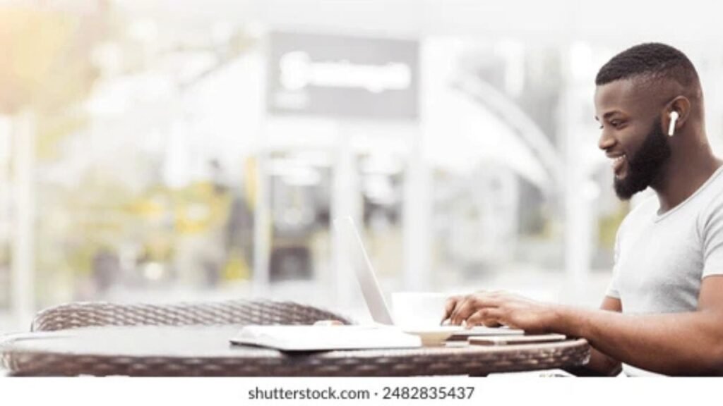 Person working in a busy coffee shop while wearing premium noise cancelling earbuds.